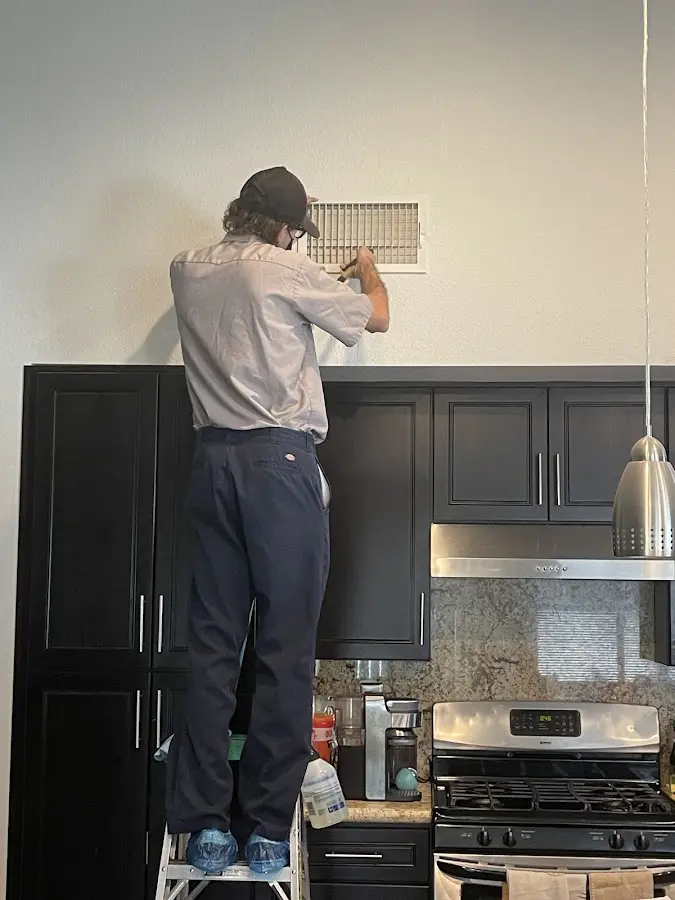 Technician inspecting an air vent during HVAC service in Rolling Hills Estates